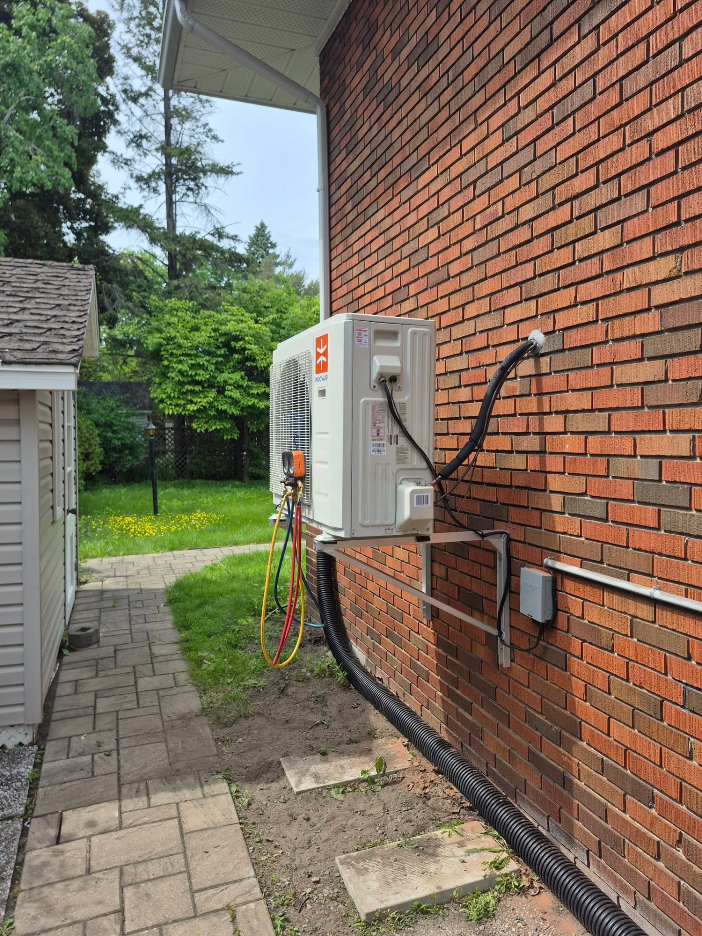Thermopompe installée sur une résidence en brique